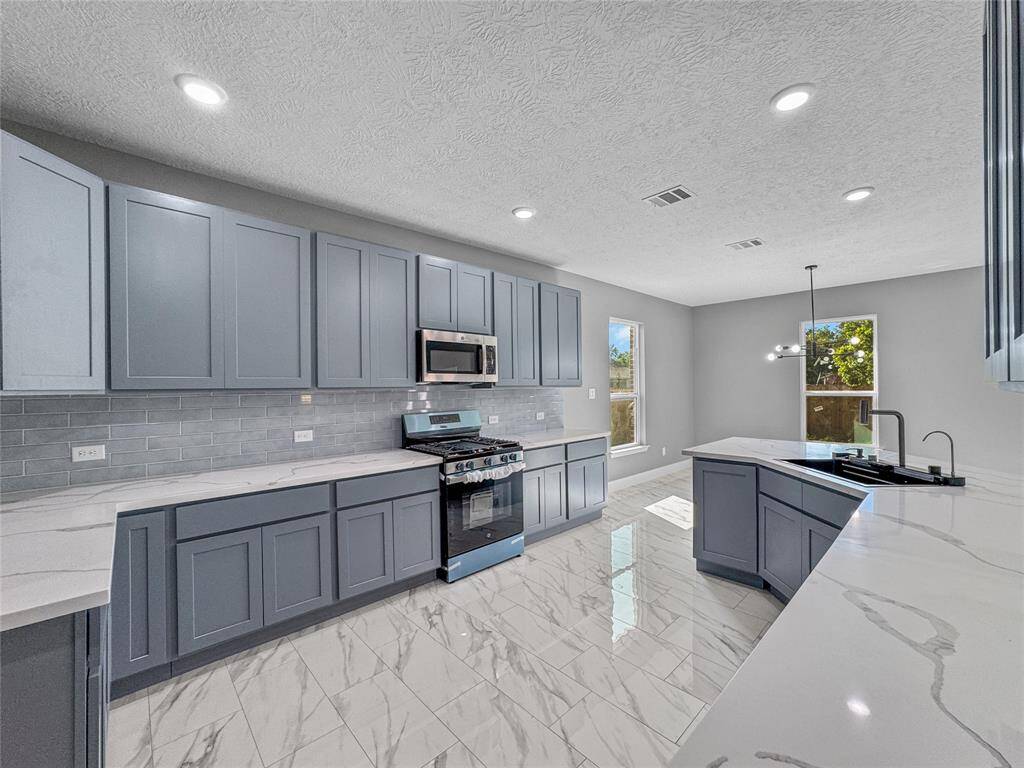 Every cook's favorite...a Gas ss range. Lots of storage in this kitchen. Beautiful cabinets with accented subway tile back splash.