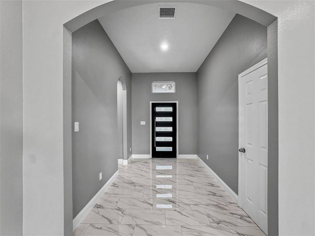 Inviting foyer leads to open concept living room. To the left you will find three bedrooms, to your right-hand side you will find a Powder room.