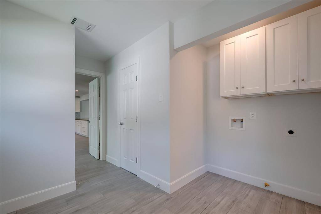 Bright and big utility room with washer and dryer connections.