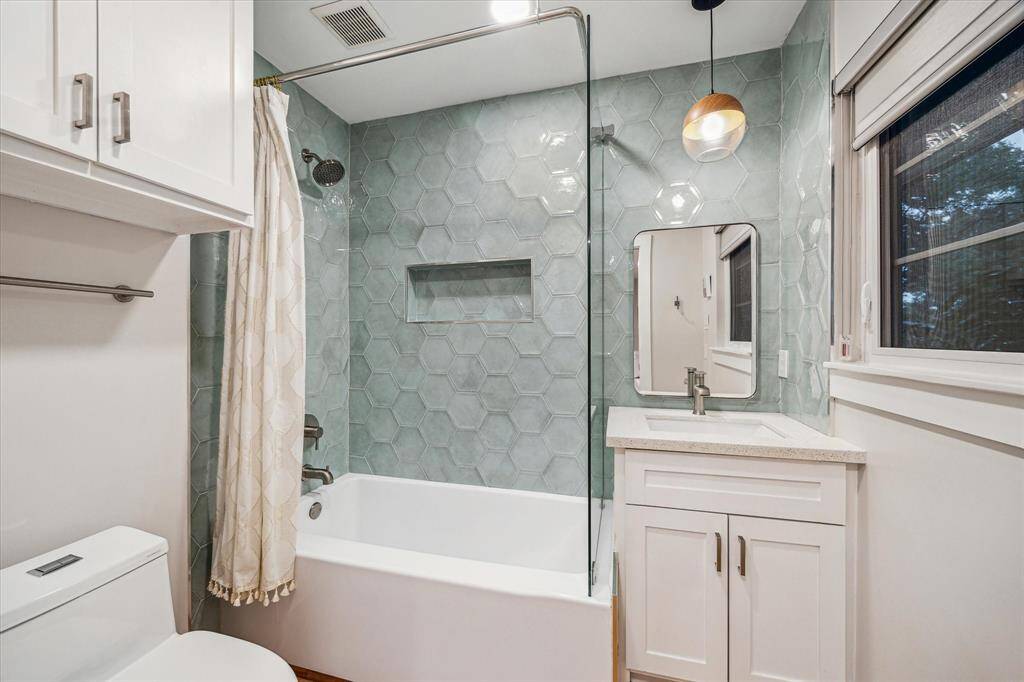Bathroom off secondary bedroom completely redone with all new vanity, fixtures, tub, lighting and decorative tile.
