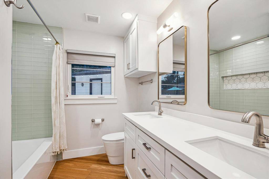 Secondary bathroom completely redone with quartz counters, dual sinks, all new fixtures, and decorate tile surrounding bathtub.