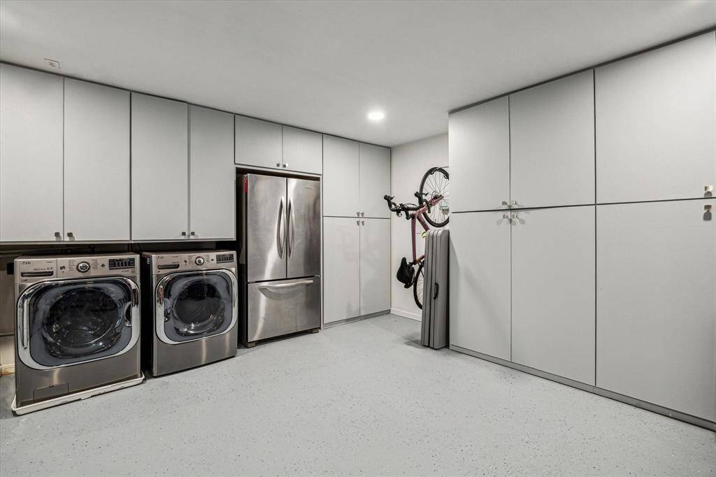 Nicely finished out garage with epoxy floor, newly added cabinets for great storage, additional washer/dryer and outdoor fridge.  Plenty of space on either side for storage, workout equipment and work bench.