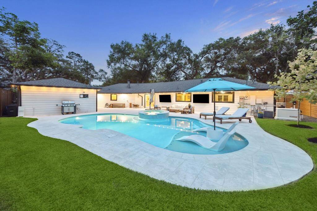 Another view of this gorgeous, tranquil private retreat surrounded by lush green grass and landscaping.