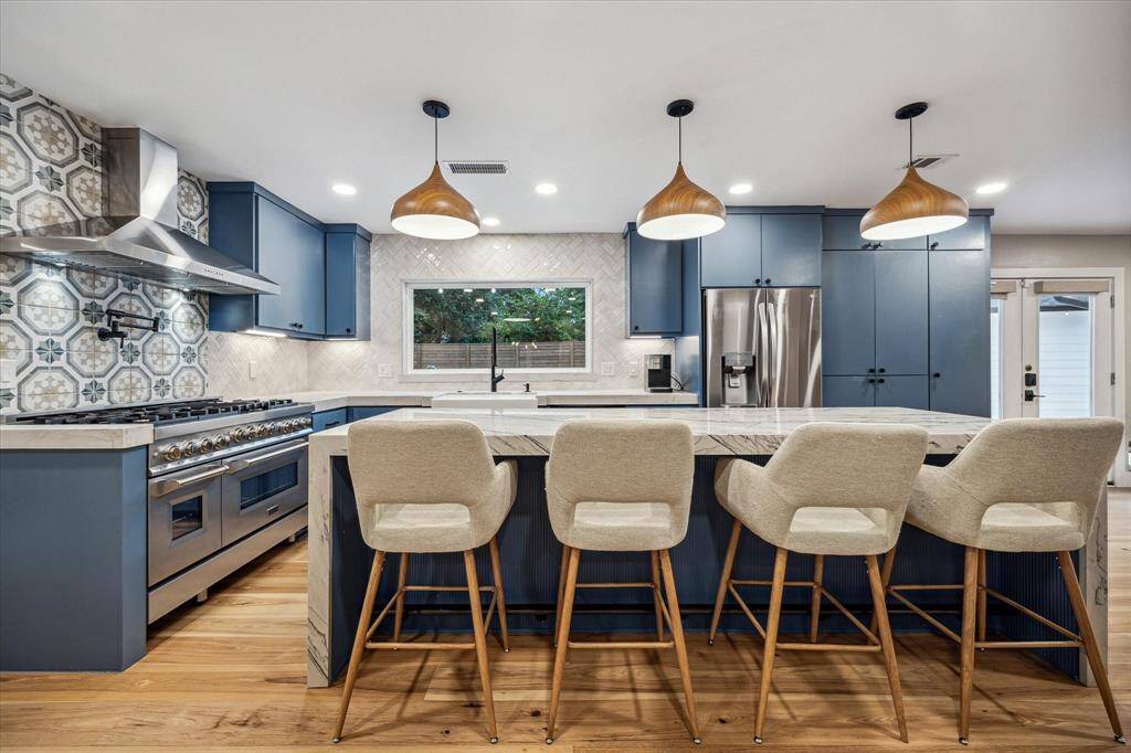 Stunning, modern kitchen with all new cabinetry, a striking quartz waterfall edge island with seating for 4, and top-tier appliances.  Enjoy views of the beautiful backyard through the large picture window that was added during the renovation.
