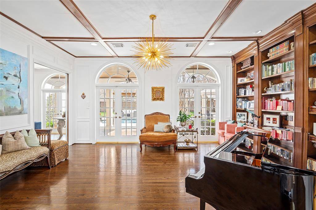 Gorgeous wood-paneled study with French doors that open to loggia. Wall of built-in lighted bookcases and cabinets. Recessed and directional lighting.