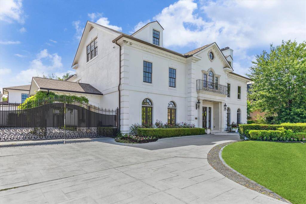 Stately Tanglewood residence sits on 18,870 sq. ft. Limestone surrounds door, circular patterned concrete driveway, double wrought iron gates allow access to porte cochere and ample parking. Two attached garages hold 5 cars.