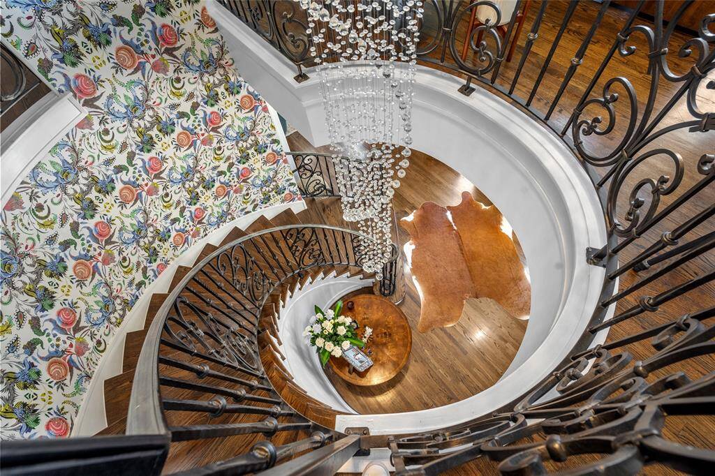 Graceful curved staircase with designer tile and designer wallpaper