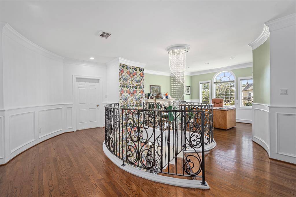 Second floor view with den/study and abundant natural light.Landing at the top of the Entryway staircase.  Custom shelves & crown molding. Light and airy, this space is perfect for a home office or comfortable seating area