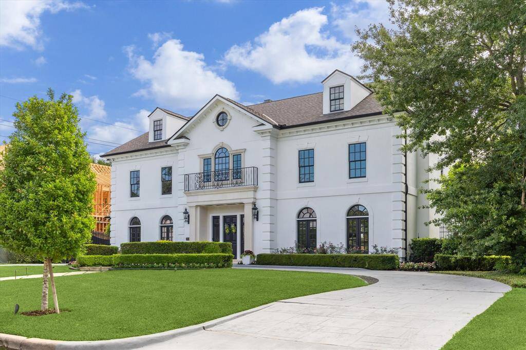 Stately Tanglewood residence sits on 18,870 sq. ft. Limestone surrounds door, circular patterned concrete driveway, double wrought iron gates allow access to porte cochere and ample parking. Two attached garages hold 5 cars.