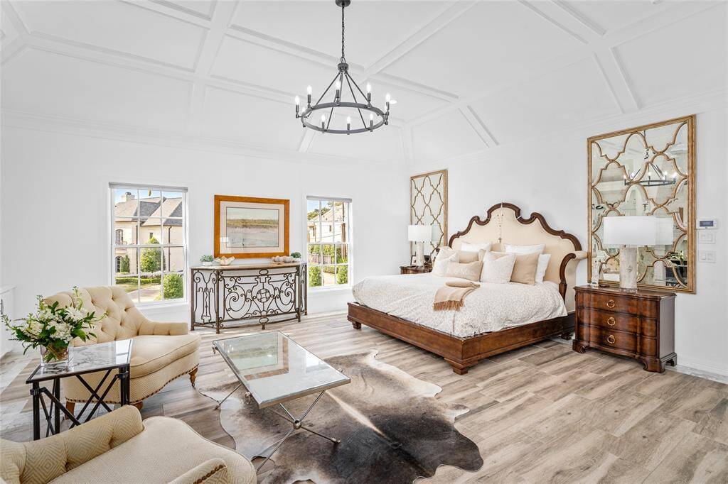 Sophisticated primary retreat has custom-carved limestone fireplace flanked by built-in shelves. Controlled, recessed lighting in elevated ceiling and was fully remodeled in 2022.