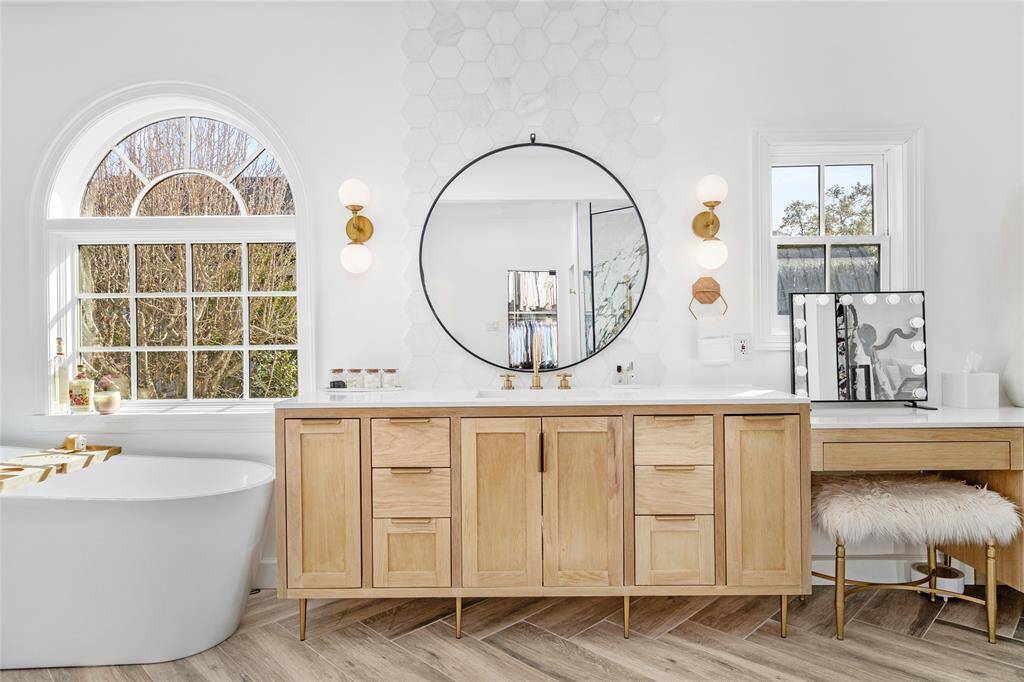 Primary bathroom oasis with heated floors, glass door entry, double vanity areas, soaking tub, and large separate shower, and abundant storage