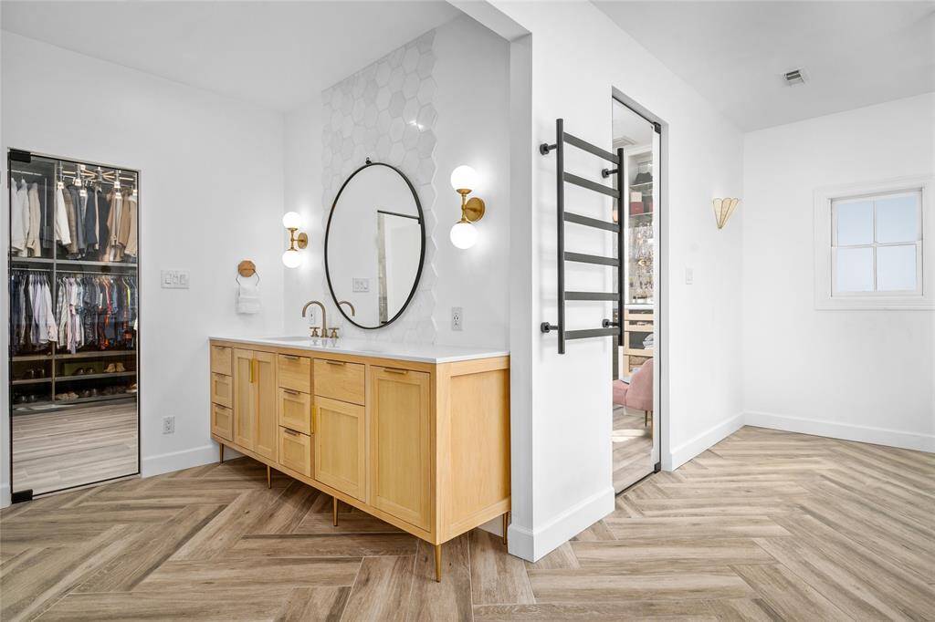 Primary bathroom oasis with heated floors, glass door entry, double vanity areas, soaking tub, and large separate shower, and abundant storage