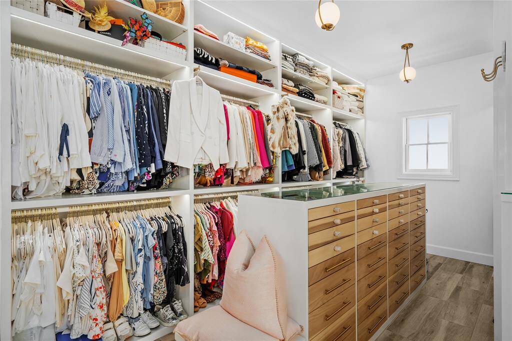 One of two large custom primary closets with abundant built-ins