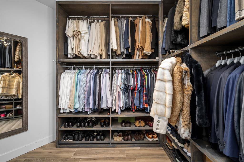 One of two large custom primary closets with abundant built-ins