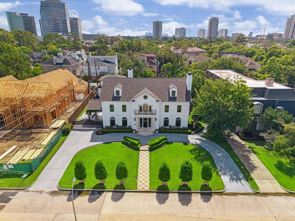 Stately Tanglewood residence sits on 18,870 sq. ft. Limestone surrounds door, circular patterned concrete driveway, double wrought iron gates allow access to porte cochere and ample parking. Two attached garages hold 5 cars.