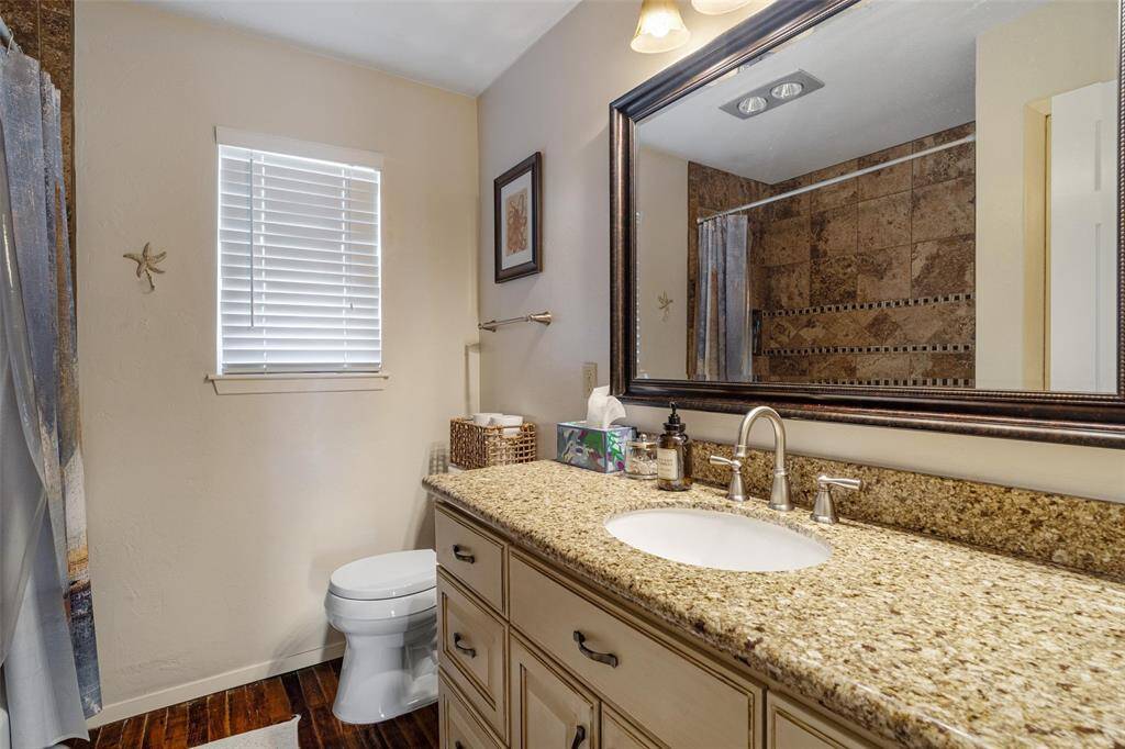 The bathroom has been tastefully updated with gorgeous cabinets, granite countertops, and lighting
