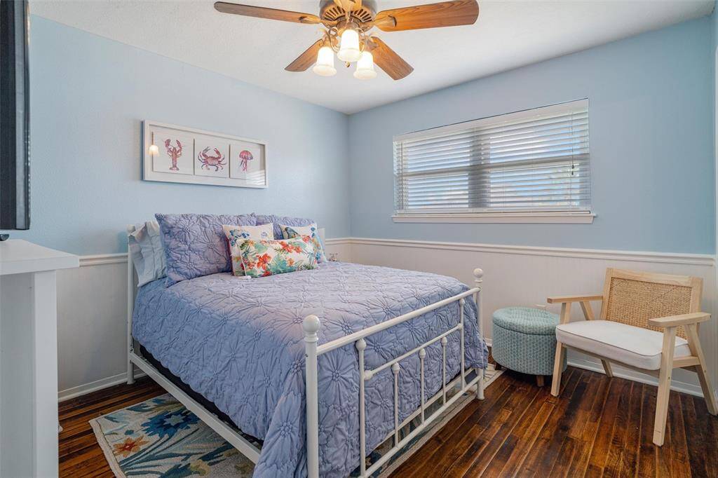The guest bedroom is painted a warm coastal color with bead board throughout