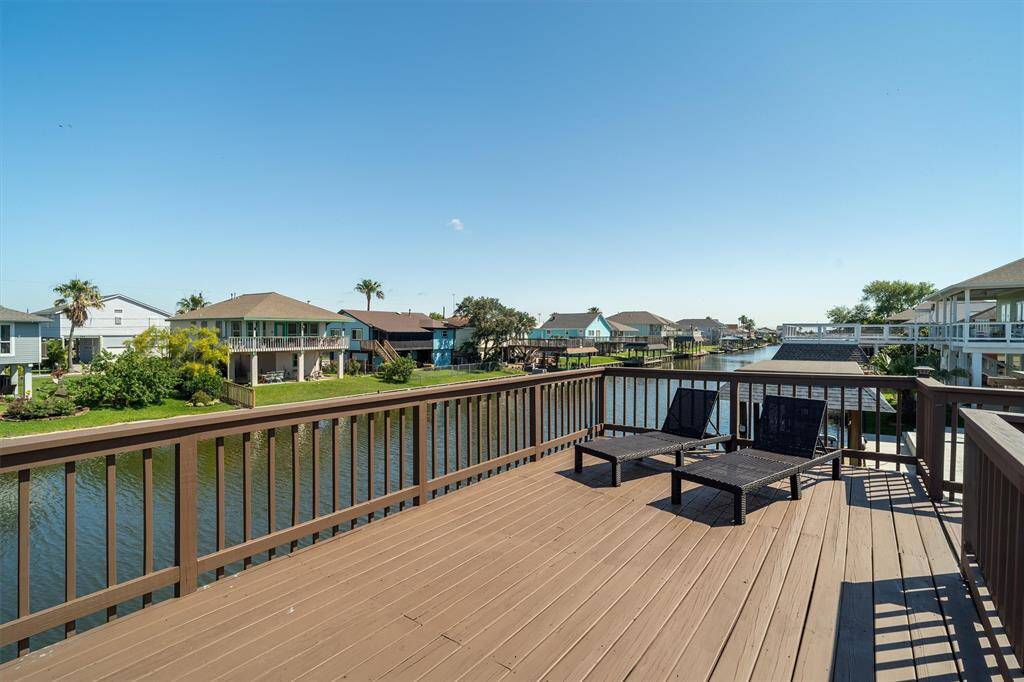 View from the upper party deck looking down the canal. This home sits far from the highway. There's plenty of room here for lounge chairs and a dining table set, or a fire pit