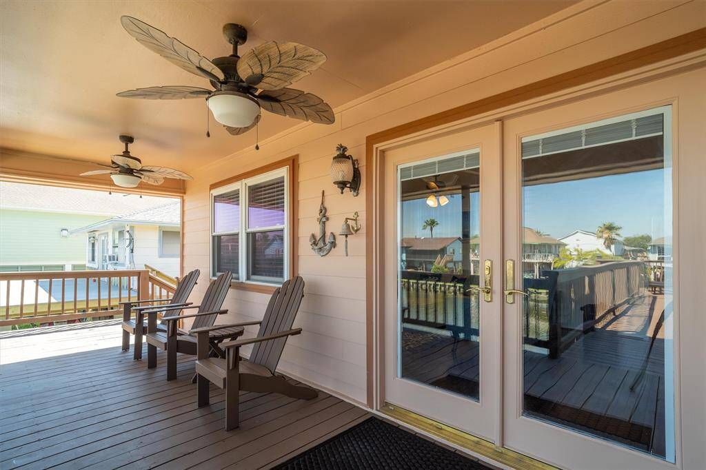 The covered porch has ceiling fans and notice the French doors for maximum water views