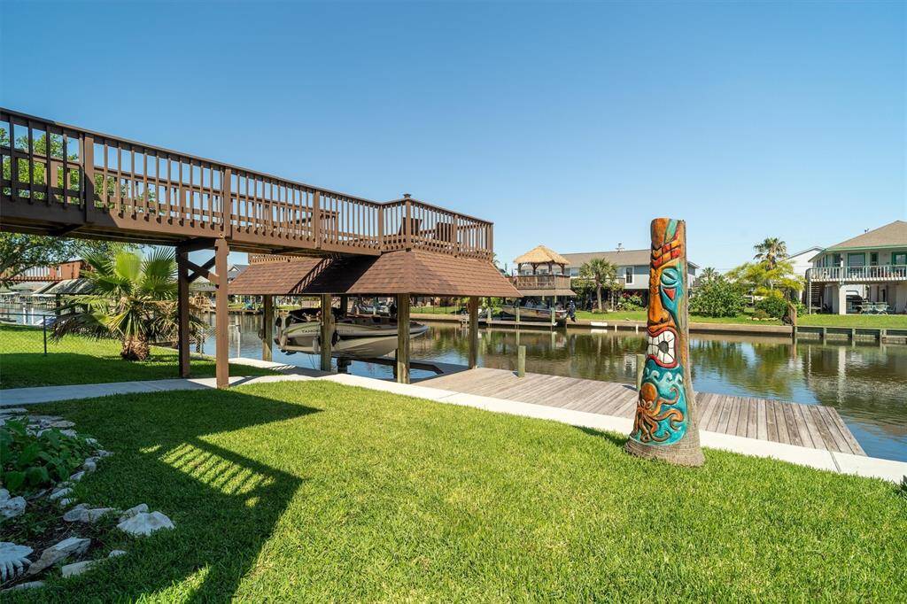 This can be your happy place! The professionally manicured lawn, custom tiki tree, sidewalk along the water, and over sized dock is where you will spend most of your time