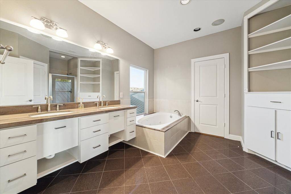 Third floor: The luxurious primary bath is designed to pamper and impress. Bathed in natural light, it features a large jetted tub perfect for unwinding, along with elegant finishes throughout. Ample built-ins provide both functionality and style, offering plenty of space for towels, toiletries, and more. Whether you're starting your day or winding down, this serene space offers the comfort and tranquility of a private spa.