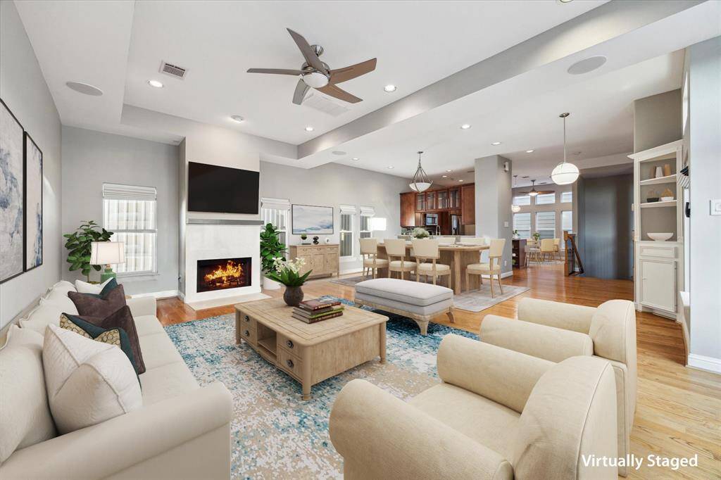 Second floor: Upstairs, you're greeted by a bright and open living and kitchen area with oak hardwood floors throughout. A cozy fireplace adds warmth and charm, while expansive windows fill the space with natural light from every angle.