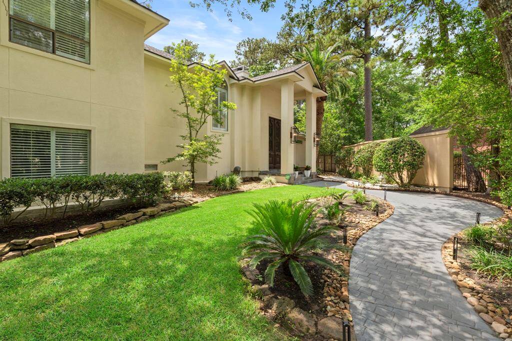 Beautiful walked way landscaped with pink roese and saga palms.