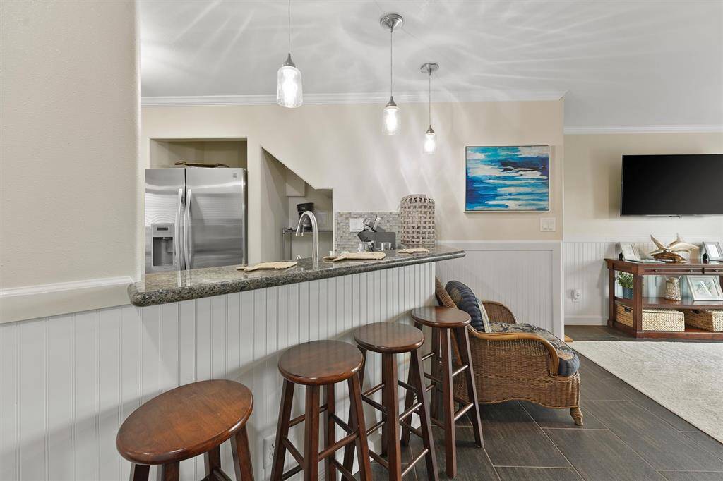 The open-concept layout features a granite breakfast bar and cozy living area, perfect for relaxing or entertaining guests.