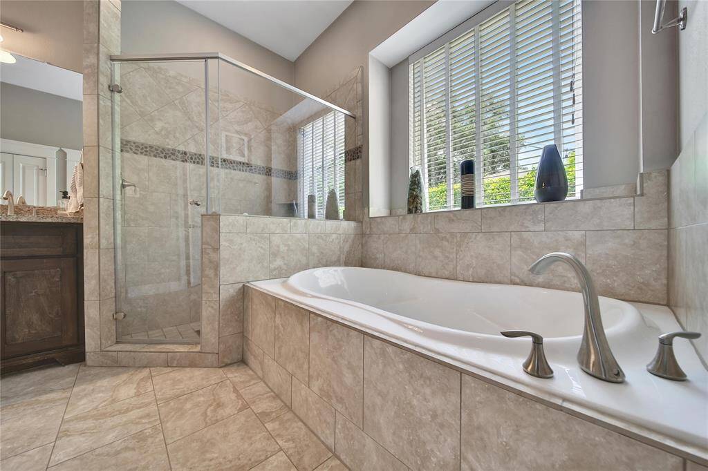 Primary bathroom features glass shower, soaking tub, double vanities, and two walk in closets.