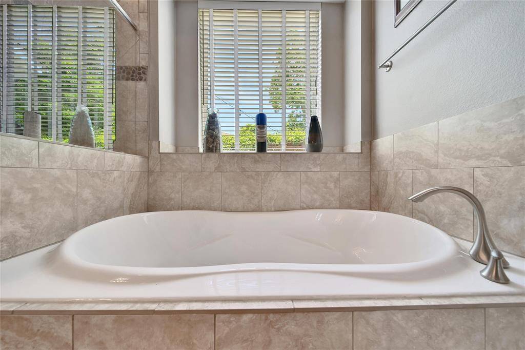 Primary bathroom features glass shower, soaking tub, double vanities, and two walk in closets.