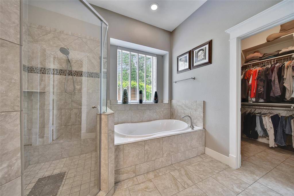 Primary bathroom features glass shower, soaking tub, double vanities, and two walk in closets.