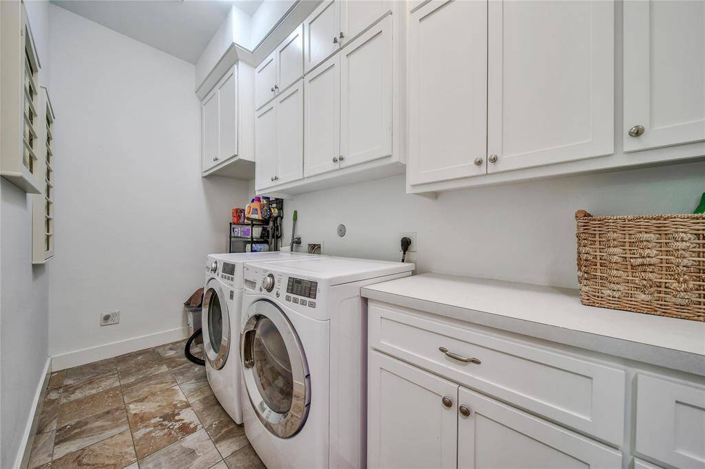 Downstairs laundry room with shaker cabinets and drying racks.
