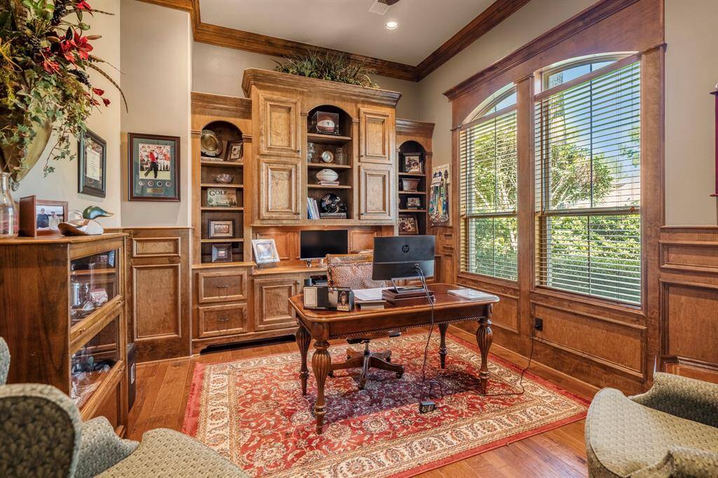 A convenient study at the front of the home with warm rich wood custom built-ins as well as real hardwood flooring.