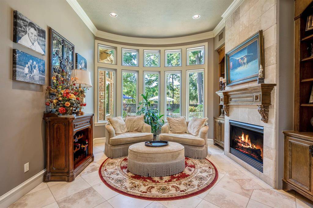 The formal living room features a cozy fireplace and massive windows in an bay window configuration making a décor statement.