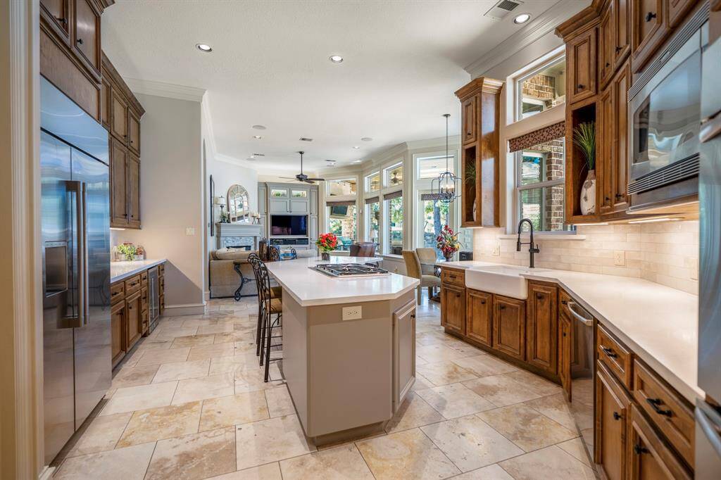 The Chef’s kitchen features updated quartz countertops, undermount farm sink, Thermador 5 burner gas range, built-in GE Monogram main & 36 wine bottle refrigerator and updated lighting.