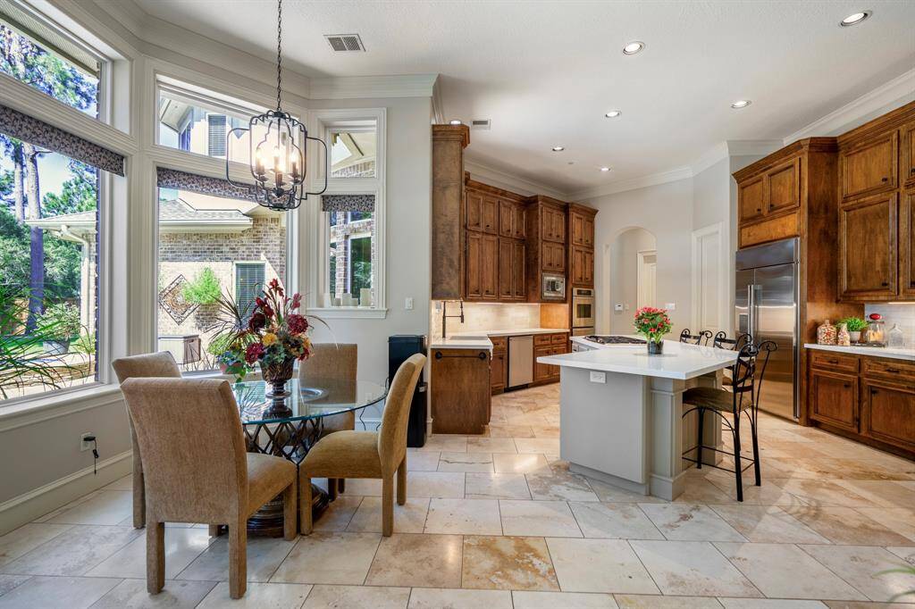 The breakfast room has crown moldings around the windows as well as a wrought iron decorative chandelier,enjoy beautiful views of the backyard  outside