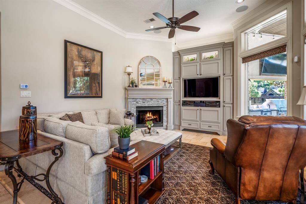 An open den / family room offers tons of natural light, with custom built-ins, as well as a majestic fireplacewhich holds center stage.