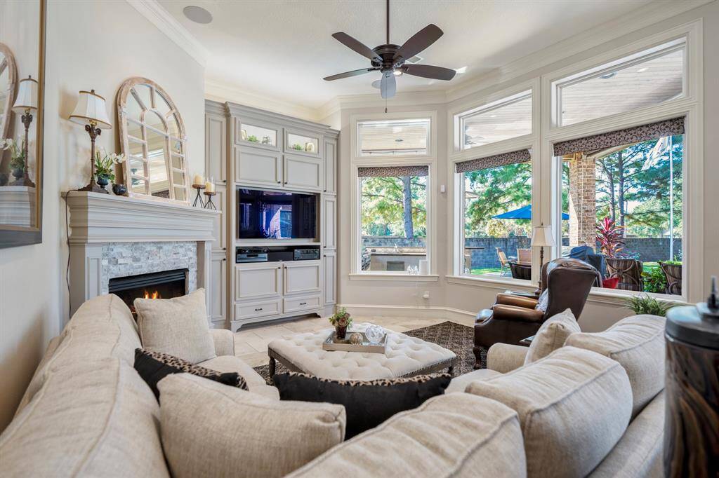 The den has custom details, crown molding, beautiful custom surround over gas log fireplace and spectacular views of the backyard beyond.