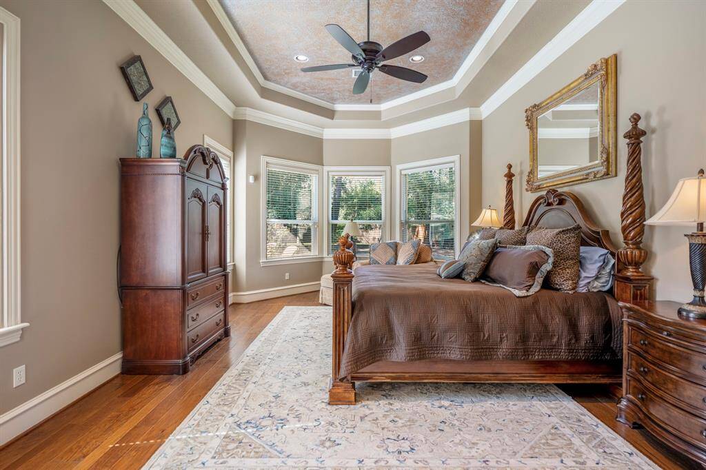 The primary owner's retreat has incredible trey ceilings, crown molding, a sitting room as well as updated hardwood floors.floors.