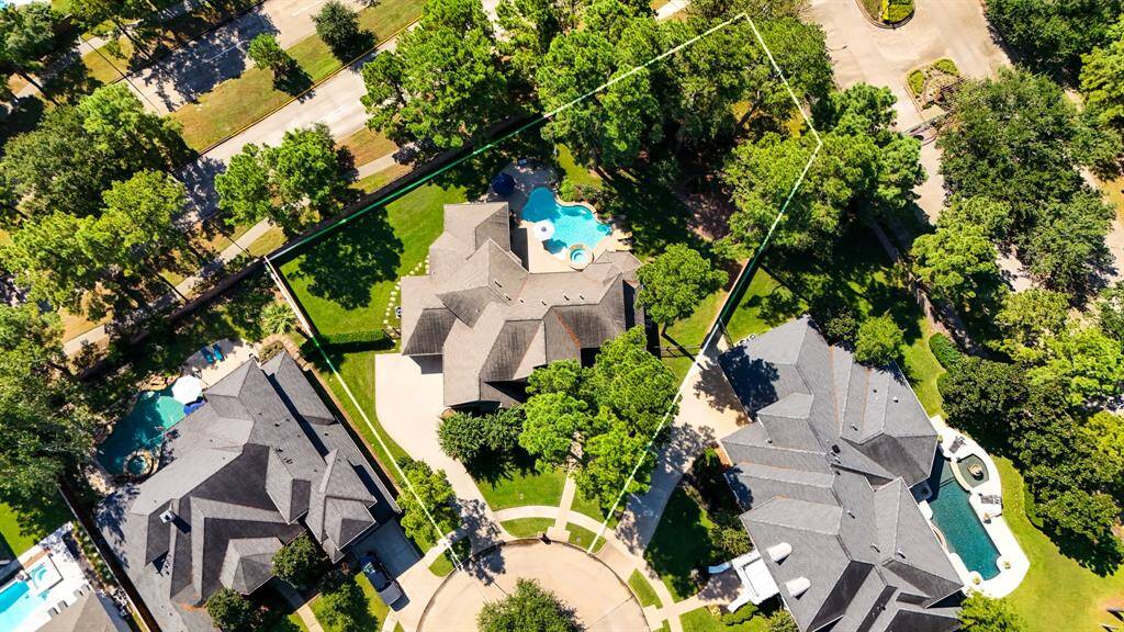 WOW! WOW! WOW! An aerial view showing the positioning of the home as it sits on the lot - offering a delightful retreat, amongst established shade trees, and offering a sparkling pool, raised spa, and beautiful shrubs and flowers. As well as a covered patio featuring an outdoor kitchen.