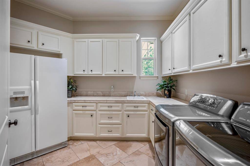 An incredible laundry room that is huge - offering lots of storage space, tons of countertop folding space, as well as an intimate sink that adds extra functionality.