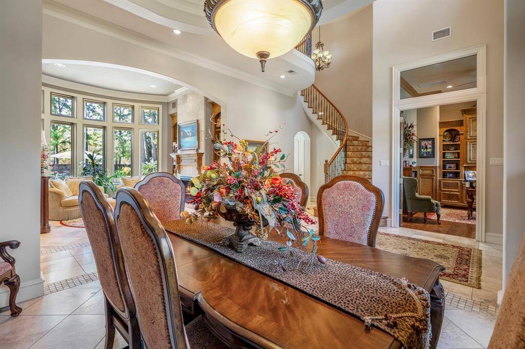 The formal dining room has a wonderful vantage point looking out onto the backyard oasis, with beautiful tiled floors, custom lighting and crown moldings.