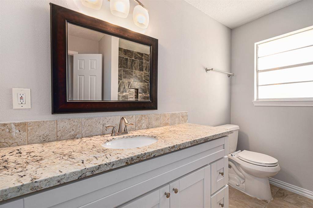 The secondary bath also features plenty of space, granite countertops, and a shower/tub combo.