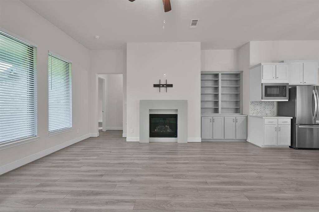 Abundant natural light accentuates the spacious living space that offers a cozy fireplace and built in shelves