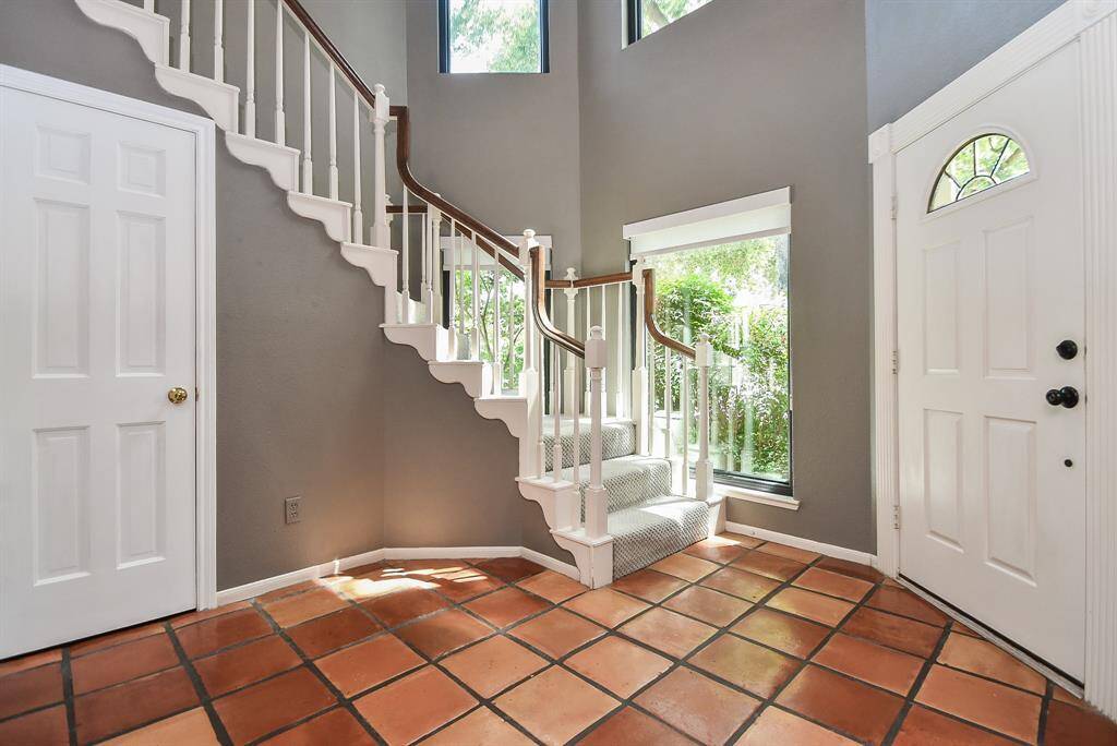 Step into this light filled entry with its gracefully winding staircase leading to the second floor.