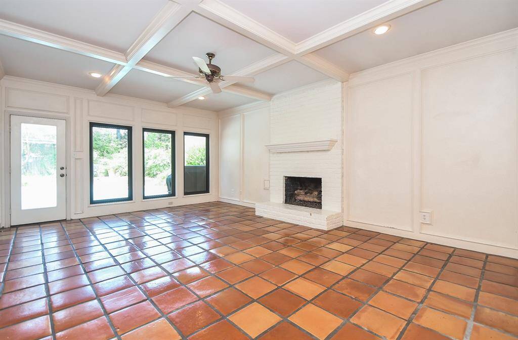 This large family room is enhanced by the fireplace with its brick surround and architectural beams on the ceiling.The beautiful,newly replaced windows let the outside in!