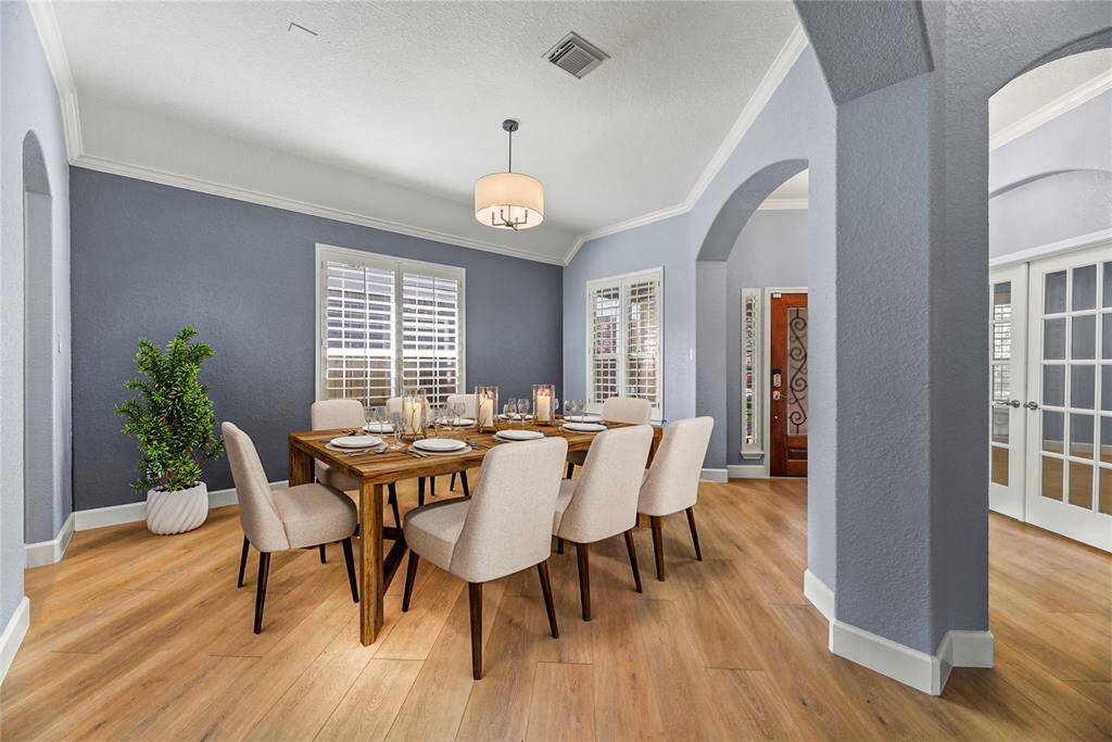 Fanciful dinners or a casual romantic dinner for two are elevated in the formal dining room. Thick white crown molding and the delicate light fixture add just the right amount of opulence for a chic dining experience.