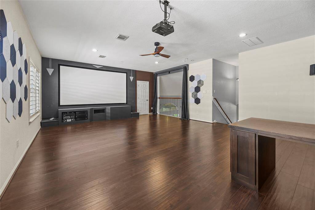Dedicated home theater room complete with built-in cabinetry, a 120" screen, mounting bracket, and pre-wiring for surround sound—perfect for movie nights and entertainment.