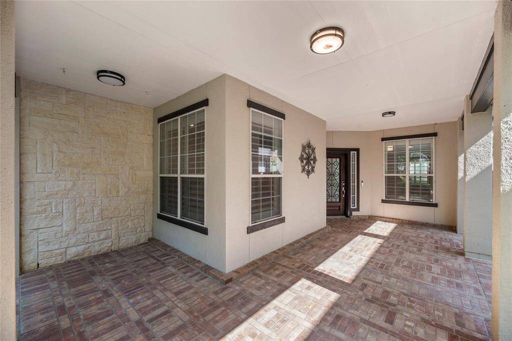 Wonderfully welcoming, the brick paved, covered front porch invites guests to stay awhile.