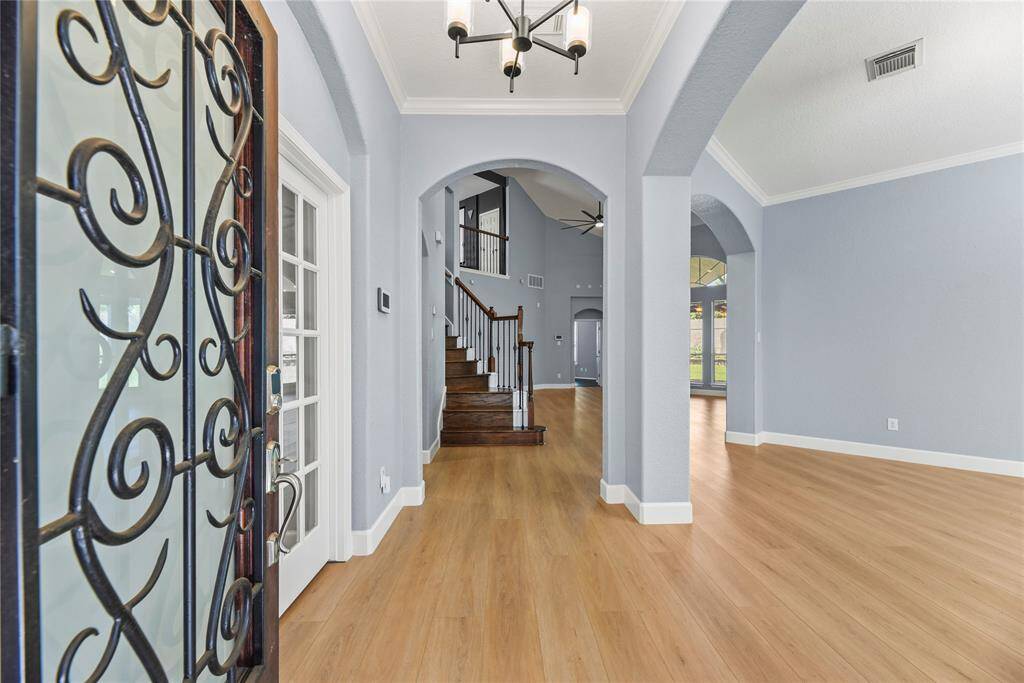 Entering the home, guests are met with new LVP flooring, which is accented with thick white baseboards and an attractive wood front door.